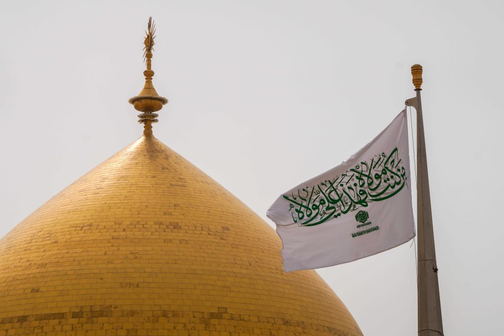 تصویر پرچم من کنت مولاه در کنار گنبد حرم امیرالمؤمنین علی علیه‌السلام