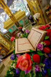 مصحف قرآن و دسته گل در مقابل ضریح امیرالمؤمنین علی علیه‌السلام