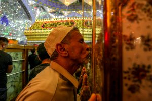 زائری در حال بوسیدن در ورودی روضه