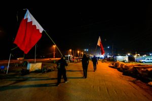 زائران بحرینی که پرچم کشورش را در پیاده روی اربعین حمل می کنند