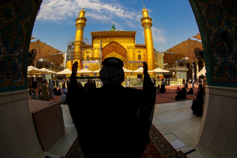 زائری در حال دعا در صحن مرقد مطهر امیرالمؤمنین