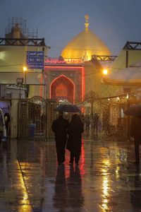 دو زائر زیر چتر روبروی حرم امیرالمؤمنین