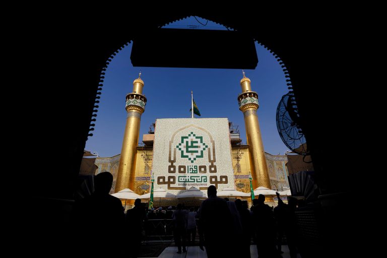 بنر من کنت مولاه بر روی ایوان طلا از ورودی حرم