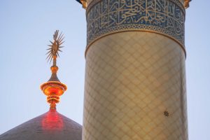 گلدسته و خورشید بالای گنبد با نور قرمز