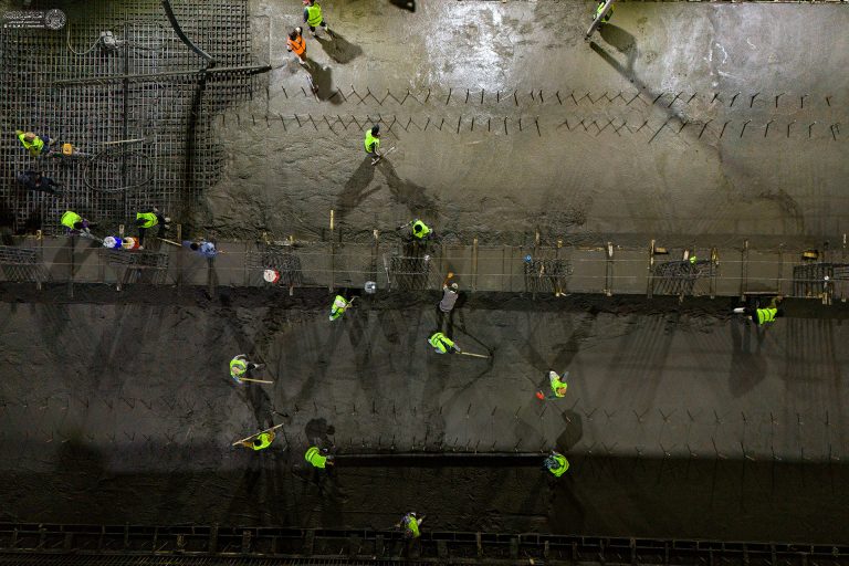 کارگران در حال تکمیل عملیات بتن‌ریزی در تقاطع غیر هم‌سطح شارع الرسول