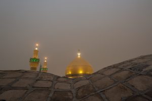 گنبد و گلدسته‌ها از پشت بام و با مه صبحگاهی