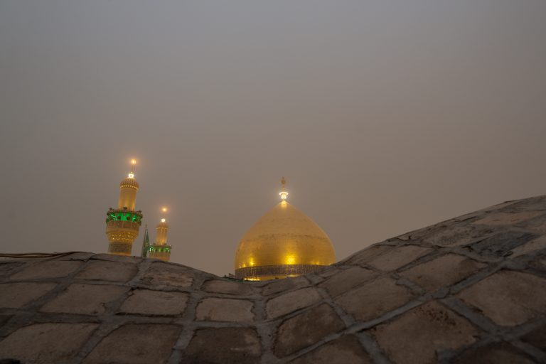 گنبد و گلدسته‌ها از پشت بام و با مه صبحگاهی