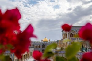 گل‌های کاغذی قرمز و صحن و سرای حرم امام علی (علیه‌السلام)