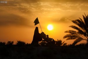 یک مادر و کودک در کالسکه در مسیر اربعین هنگام غروب