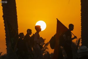 جوانانی در حال طی طریق پیاده اربعین هنگام غروب