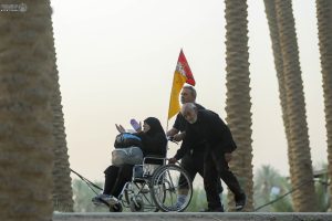 مردی پدر و مادر پیر خود را به پیاده‌روی اربعین آورده
