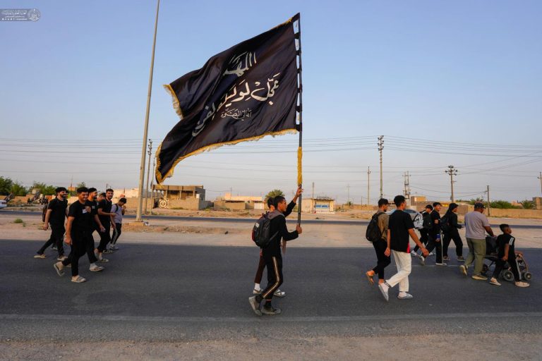 زائر اربعین با پرچم اللهم عجل لولیک الفرج