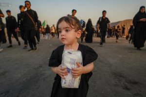 دختر بچه در حال تعارف دستمال، مسیر اربعین