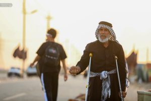 پیرمردی در حال پذیرایی از زوار اربعین