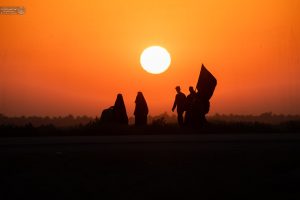 یک خانواده هنگام غروب در مسیر اربعین حرکت می‌کند