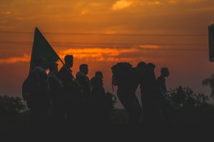 سایه چند زائر در نور غروب در حال حرکت به سمت کربلا