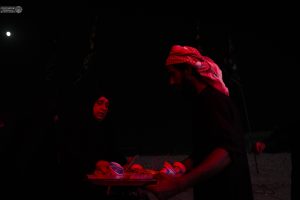 خادم موکب در حال تقدیم غذا در شب