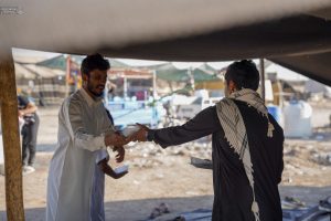 خادم موکب در حال تقدیم غذا به زوار پیاده