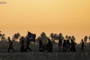 مجموعه‌ای از زنان و مردان که خانوادگی در پیاده‌روی اربعین شرکت کرده‌اند
