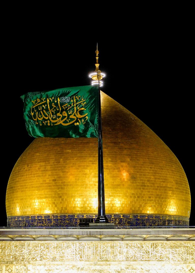 نمای نزدیک گنبد طلایی و پرچم سبز حرم امیرالمؤمنین علی (علیه‌السلام)