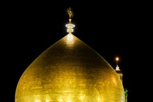 بخش بالایی گنبد طلایی حرم امیرالمؤمنین با گلدسته در پس‌زمینه