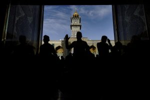 سیلوئت زائران در ورودی حرم با نمای مناره ساعت