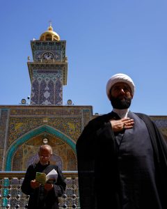 نمای مناره ساعت حرم علوی و حضور دو زائر در صحن