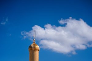 نمای قسمت بالای گلدسته حرم امیرالمؤمنین و ابرهای سفید
