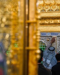 جزئیات طلایی در ورودی و ضریح و زائری در حال زیارت
